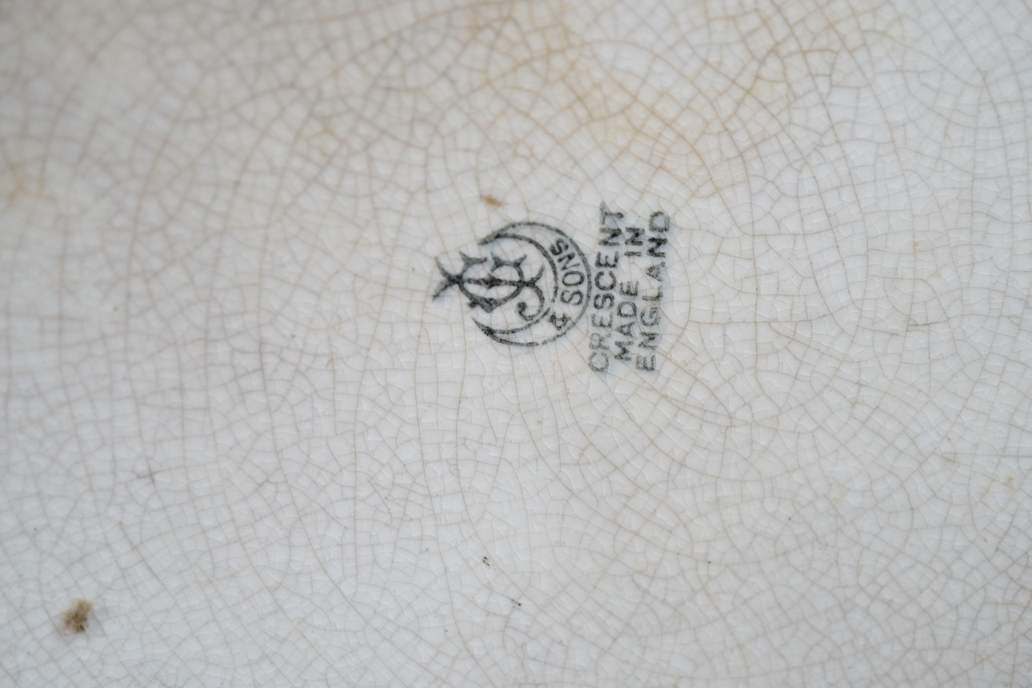 A George Jones & Sons crescent pottery floral wall plate and a similar Staffordshire example, 37cm in diameter
